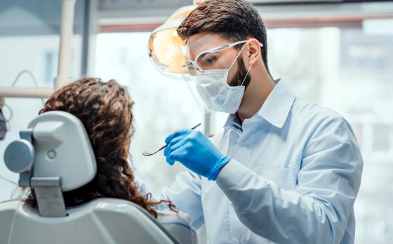 male dental assistant looking in patient's mouth